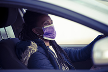 Woman driving in car with mask on